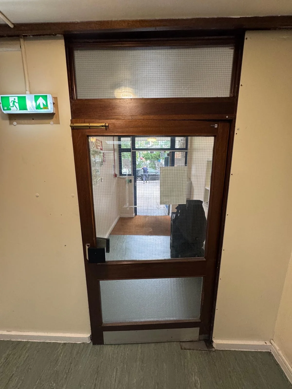 Existing glazed communal corridor door before replacement, first side