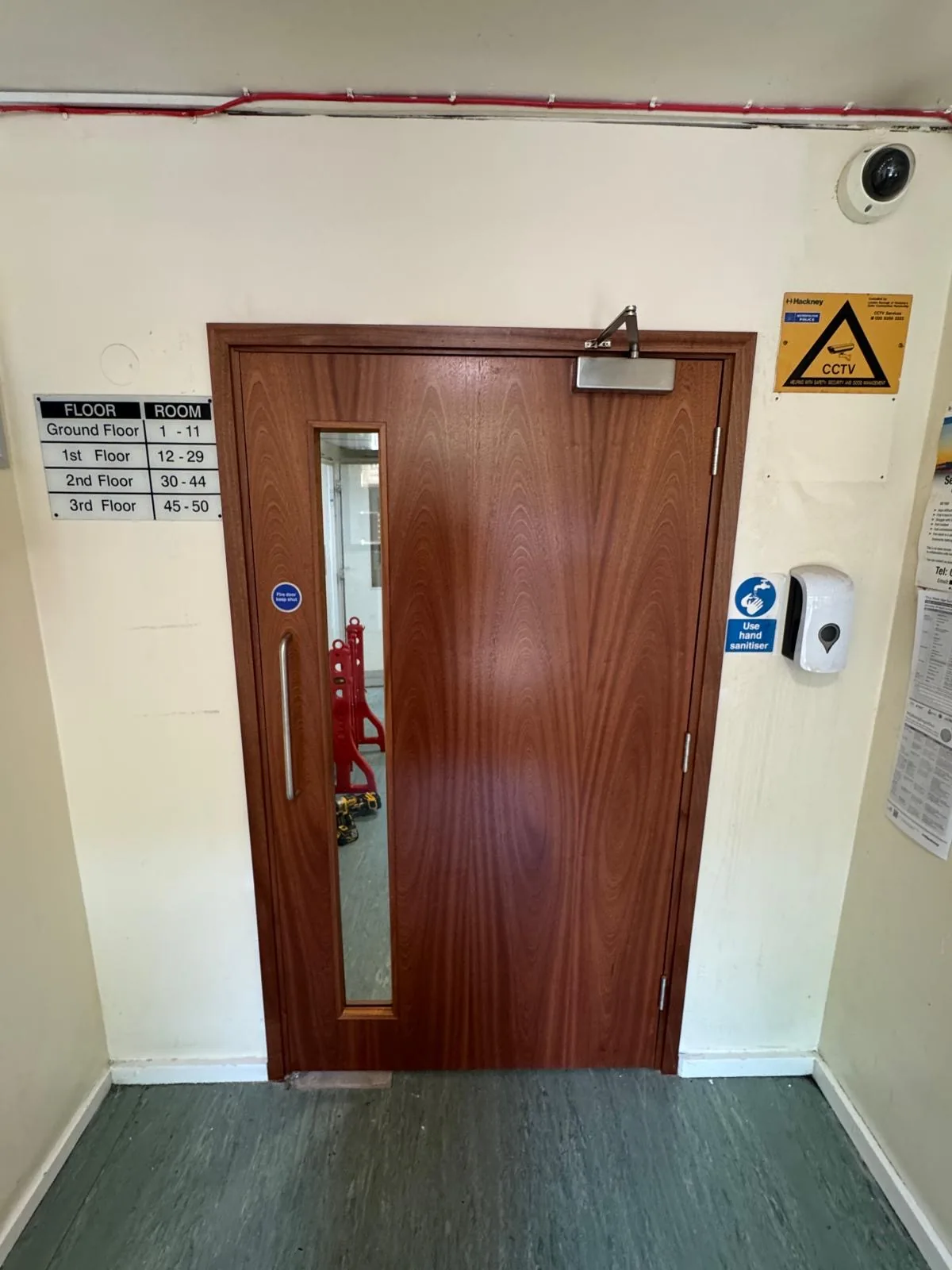 New timber communal fire door with closer and narrow glazed vision panel, opposite side